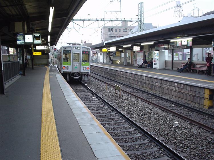 芦花公園駅を通過する都営新宿線車両の急行